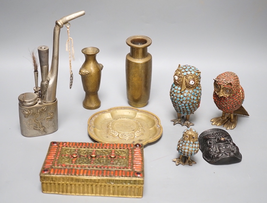 A Chinese water pipe, two Chinese bronze vases, a similar cup stand, a mask, three metal and enamel owl figures and a box